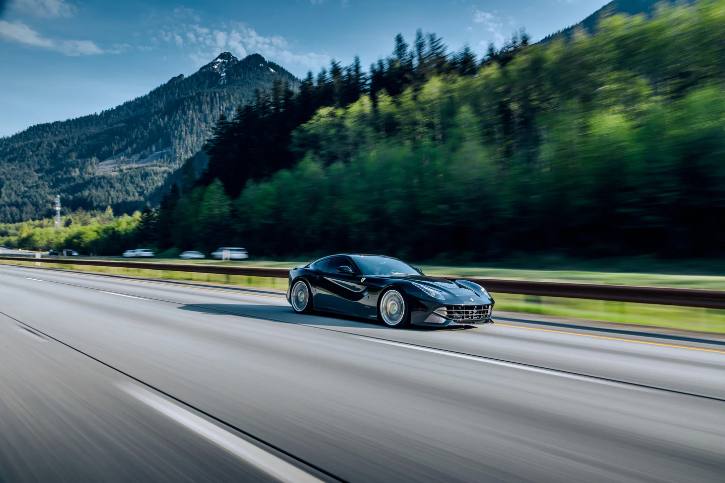 Dark supercar on a mountain road in summer