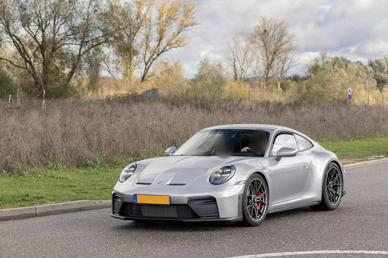 Silver Porsche 992.2 GT3 Touring on a country road